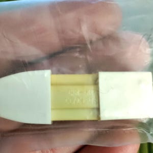 May include: A white and yellow plastic eraser with the text "CRAYOLA COLOR