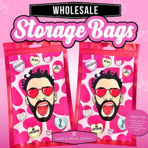 May include: Two pink plastic bags with a Valentine's Day theme. The bags feature a cartoon man with a beard and sunglasses. The bags have a white background with pink hearts and candy hearts with Spanish text. The text on the bags reads "Wholesale Storage Bags" and "Lash & Brow Supply".