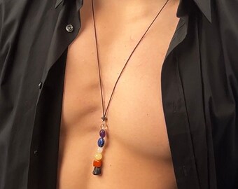 May include: A black cord necklace with a pendant featuring seven colorful gemstones in a rainbow pattern. The pendant is made of amethyst, lapis lazuli, rose quartz, carnelian, citrine, tiger's eye, and black obsidian.