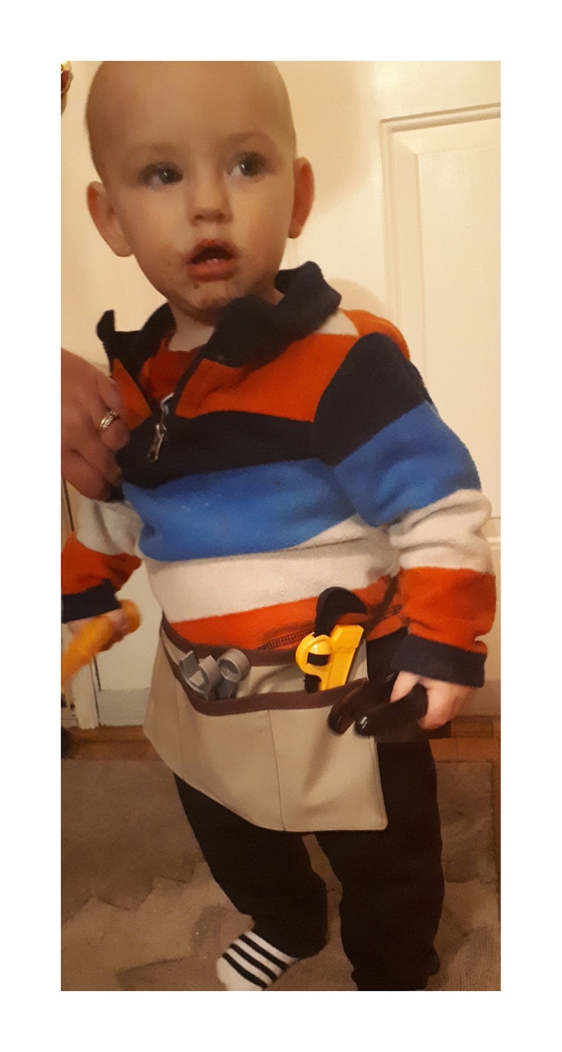Tiny toolbelt modelled by small child, approximately 18 months old.