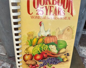 May include: A yellow cookbook with the title "Cookbook 25 Years Women of the Farm Bureau" and a colorful illustration of a chicken, vegetables, and fruit.