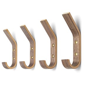 May include: Set of four wooden wall hooks in a dark brown finish. The hooks are made of wood veneer and have a curved shape. They are ideal for hanging coats, hats, bags, or other items.