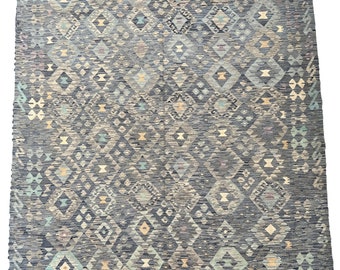 May include: A gray and blue patterned rug with a geometric design. The rug has a fringe border.