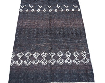 May include: A dark gray and white patterned rug with a geometric design. The rug has a subtle gradient of color from dark gray to light gray.