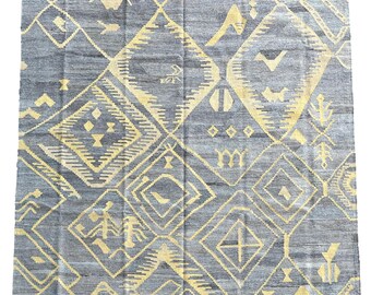 May include: A gray and yellow patterned rug with a geometric design. The rug has a fringed edge.