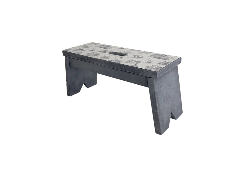 Peut inclure: Un tabouret en bois gris avec un dessus &agrave; motif blanc. Le tabouret a un design simple avec deux pieds de chaque c&ocirc;t&eacute;.