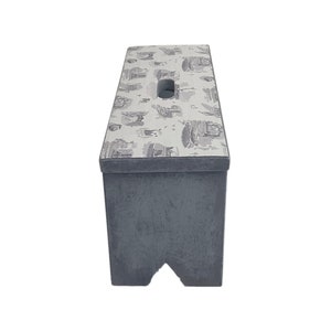 Peut inclure: Un tabouret en bois gris avec un dessus blanc orn&eacute; d'un motif noir et blanc. Le tabouret a une poign&eacute;e d&eacute;coup&eacute;e sur le dessus.