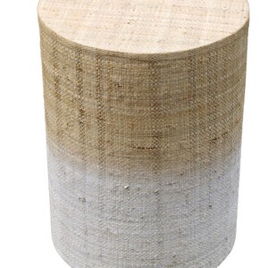 May include: A round, woven stool with a white ombre effect. The stool is made of natural fibers and has a rustic, farmhouse style.