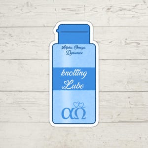 K&ouml;nnte beinhalten: Ein blauer Aufkleber in Form einer Flasche mit den Worten "knotting Lube" in einer Schreibschrift. Der Aufkleber enth&auml;lt auch den Text "Alpha Omega Dynamics" und die griechischen Buchstaben Alpha und Omega.