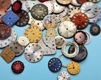 May include: A collection of vintage watch faces in various shapes, sizes, and colors, including round and square designs. The faces display numerals and markings in black, gold, and white, with a few featuring the brand name "SLAVA" and "ZARJA".