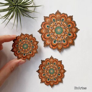 K&ouml;nnte beinhalten: Drei braune und gr&uuml;ne Mandala-Aufkleber mit komplizierten Designs. Der gr&ouml;&szlig;te Aufkleber befindet sich in der Mitte des Bildes, die beiden kleineren Aufkleber befinden sich links und rechts vom mittleren Aufkleber.