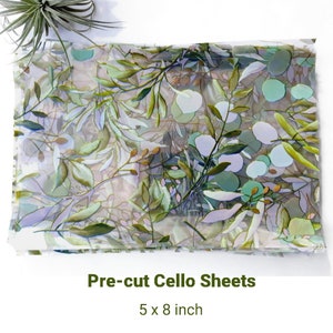 May include: A stack of pre-cut cellophane sheets with a leafy green and blue floral pattern. The sheets are 5 x 8 inches.