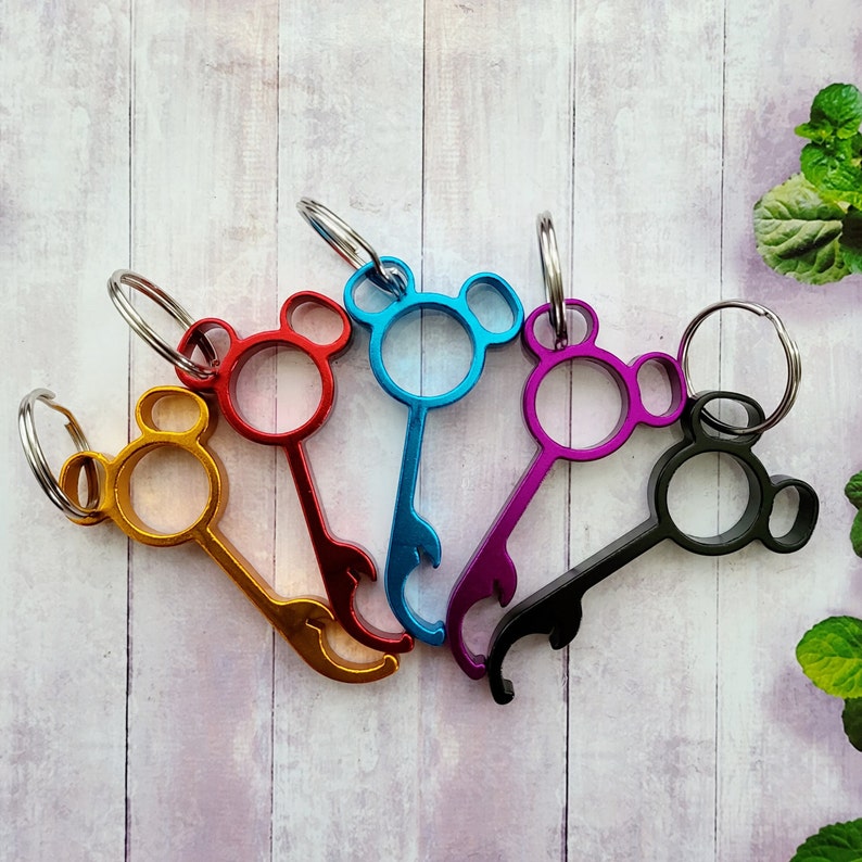 Puede incluir: Cinco llaveros coloridos con funciones de abridor de botellas. Cada llavero tiene un dise&ntilde;o de cabeza de oso de dibujos animados. Los llaveros son azules, rojos, morados, negros y dorados.