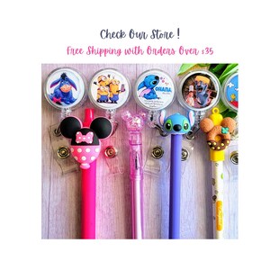 May include: A collection of pens with character-themed toppers, including Eeyore, Minions, Stitch, and Mickey Mouse. The pens are in various colors, such as pink, purple, and blue. The image also includes the text "Check Our Store!"