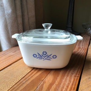 Peut inclure: Plat à gratin blanc avec un motif floral bleu et un couvercle en verre transparent.