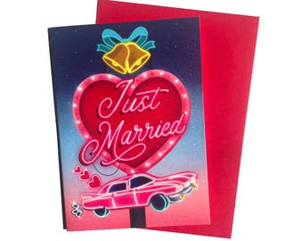 Könnte beinhalten: Hochzeitskarte mit rotem Umschlag. Die Karte zeigt ein Design im Neon-Stil mit einem Herzen, den Worten "Just Married", einem Auto und Glocken. Der Hintergrund wechselt von Blau zu Rosa.