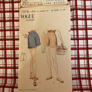 May include: Vintage Vogue pattern envelope featuring illustrations of shorts. The envelope has the text "VOGUE PATTERN" and "7078-50c in Canada 55c 30 Waist 39 Hip". The background is a red and white checkered pattern.