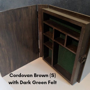 May include: A wooden box with a hinged lid, stained in a Cordovan Brown finish. The interior is lined with dark green felt and has multiple compartments.