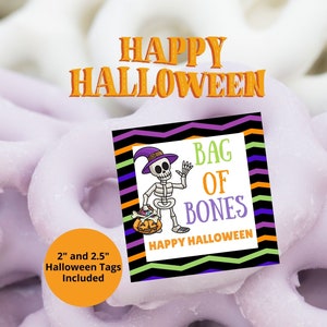 May include: A square Halloween tag featuring a skeleton wearing a purple hat and holding a pumpkin bucket. The text reads BAG OF BONES and HAPPY HALLOWEEN. The border has black, purple, orange, and green zig-zag lines. 2 inch and 2.5 inch tags included.