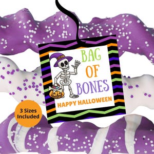 May include: A square tag with a black ribbon featuring a skeleton wearing a purple hat, holding a pumpkin, and the text BAG OF BONES HAPPY HALLOWEEN. The tag has a chevron border in black, orange, purple, and green. Three twisted pretzel rods are visible.