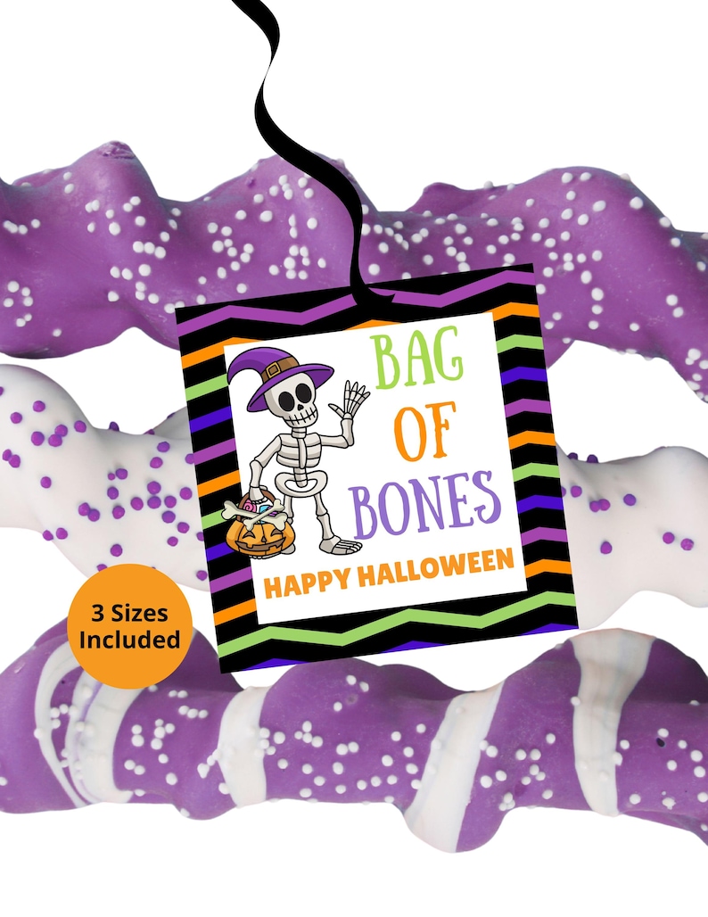 May include: A square tag with a black ribbon featuring a skeleton wearing a purple hat, holding a pumpkin, and the text BAG OF BONES HAPPY HALLOWEEN. The tag has a chevron border in black, orange, purple, and green. Three twisted pretzel rods are visible.