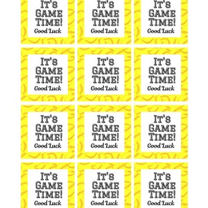 May include: A sheet of twelve yellow and white softball-themed gift tags. Each tag has a yellow background with a softball pattern. The text "IT'S GAME TIME! Good Luck" is printed in black.
