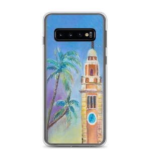 Peut inclure: Une coque de téléphone avec une peinture d'un bâtiment orange haut avec un cadran d'horloge et un ciel bleu avec des palmiers.