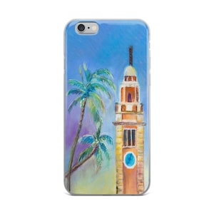 Peut inclure: Une coque de téléphone avec une peinture d'un immeuble jaune et haut avec un cadran d'horloge et un palmier devant. Le ciel est bleu et le bâtiment a un dôme blanc au sommet.