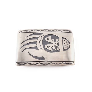 May include: Silver belt buckle with a bear paw print design.