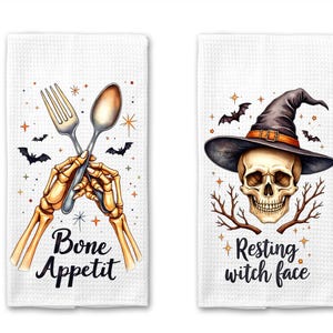May include: Two white Halloween-themed kitchen towels. One features a skeleton's hands holding a fork and spoon, with the text "Bone Appetit." The other shows a skull wearing a witch hat, with the text "Resting witch face."