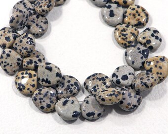 May include: A strand of natural dalmatian jasper gemstone beads. The beads are a light gray color with black and brown spots. The beads are smooth and polished.