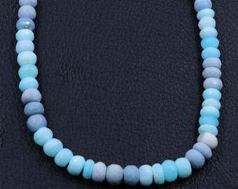 Puede incluir: Una hebra de cuentas de piedras preciosas azules y blancas. Las cuentas son facetadas y tienen un degradado de azul claro a blanco.