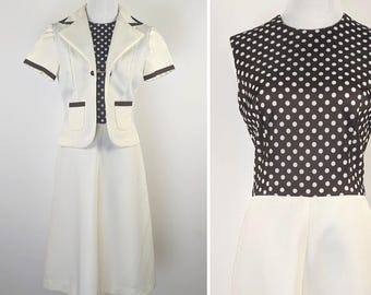 Puede incluir: Un vestido blanco con un corpiño de lunares marrones y una chaqueta a juego. La chaqueta tiene ribetes y bolsillos marrones. El vestido tiene manga corta y una falda hasta la rodilla.