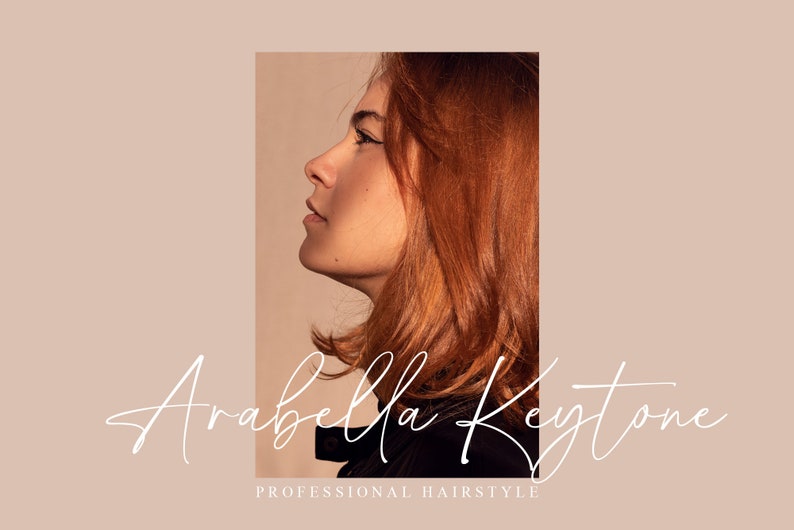 Op de afbeelding: Een vrouw met lang, rood haar is in profiel te zien. De tekst "Arabella Keystone" is geschreven in een wit, cursief lettertype onder de afbeelding. De tekst "Professional Hairstyle" is geschreven in een kleiner, wit lettertype onder de cursieve tekst.