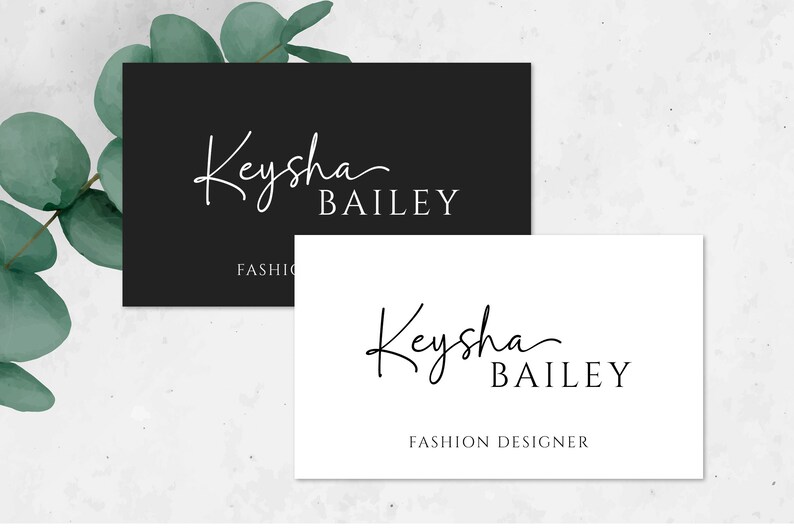 May include: Two business cards with a black and white design. The top card has a black background with white text that reads "Keysha Bailey" and "FASHION". The bottom card has a white background with black text that reads "Keysha Bailey" and "FASHION DESIGNER".