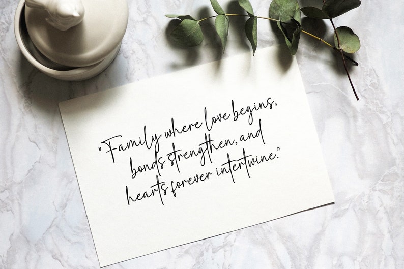 May include: A white card with black calligraphy that reads "Family where love begins, bonds strengthen, and hearts forever intertwine."