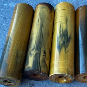 Peut inclure: Quatre boutons cylindriques en bois marbré brun doré et noir avec des extrémités filetées.