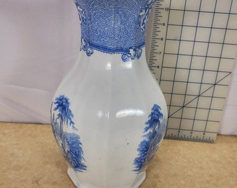 Könnte beinhalten: Eine weiße Keramikkanne mit einem blauen und weißen Blumenmuster. Die Kanne hat eine breite Öffnung und einen Henkel. Sie ist etwa 28 cm hoch.