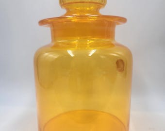 Peut inclure: Un pot en verre ambré transparent avec un couvercle. Le pot a un corps rond et une large ouverture. Le couvercle a un motif en relief texturé.