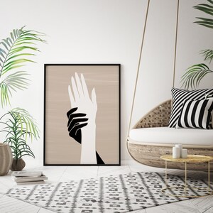 Puede incluir: Una impresi&oacute;n de arte minimalista en blanco y negro de dos manos que se sostienen mutuamente. Las manos est&aacute;n delineadas en negro sobre un fondo beige.