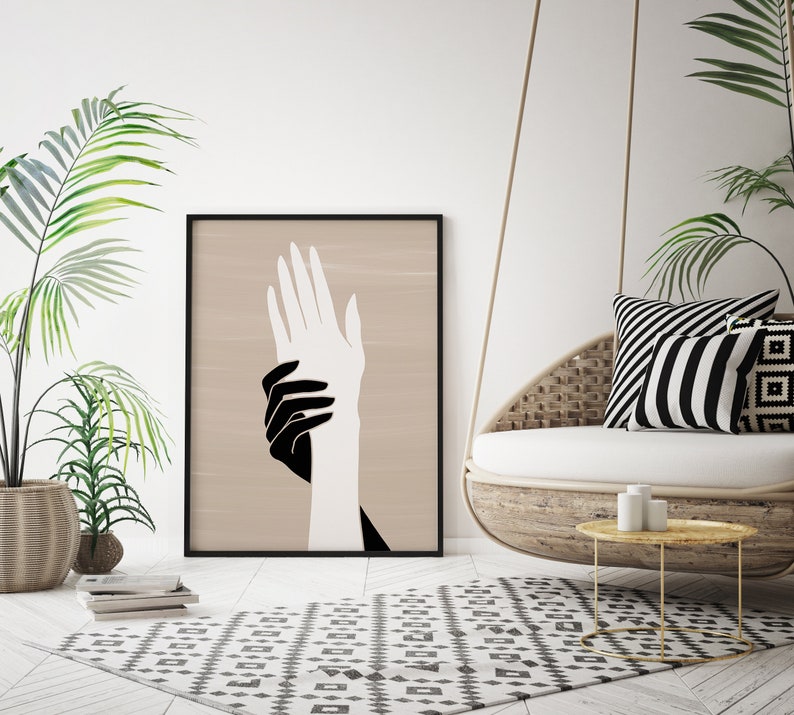 Puede incluir: Una impresi&oacute;n de arte minimalista en blanco y negro de dos manos que se sostienen mutuamente. Las manos est&aacute;n delineadas en negro sobre un fondo beige.