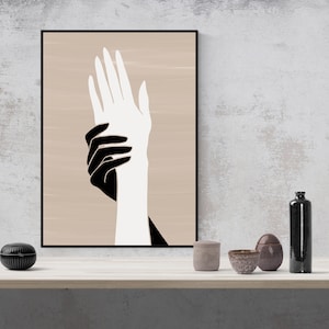 Puede incluir: Impresi&oacute;n de arte abstracto con dos manos, una negra y una blanca, superpuestas sobre un fondo beige.