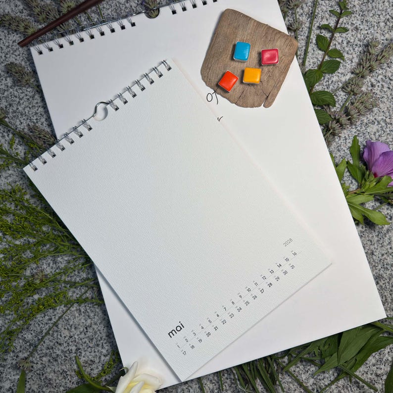 Größenvergleich: Maiseite „mai“ im Design Minimal auf dem großen A3-Blankokalender – handgemachte Aquarellnäpfchen und Frühlingsblumen daneben