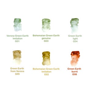 Op de afbeelding: Een verzameling aquarelverfstalen in groen- en bruintinten. De stalen zijn gelabeld met namen als "Verona Green Earth" en "Bohemian Green Earth". Elk staal heeft een unieke kleur en textuur, waarbij het "Green Earth burnt" staal een roodbruine tint laat zien.