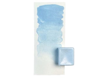 Può includere: Un singolo panno di acquerello di colore azzurro chiaro. Il panno è appoggiato su un foglio bianco con un lavaggio ad acquerello azzurro chiaro.
