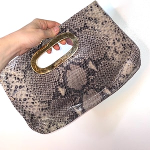 Cartera de mano Michael Kors de piel de serpiente y dorada
