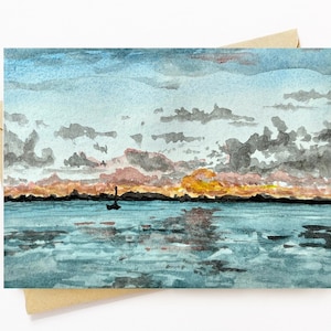May include: Watercolor painting of a sunset over a calm body of water with a small boat in the distance. The sky is a mix of pink, orange, and blue with dark clouds. The water is a light blue with reflections of the sky.