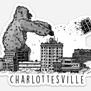 May include: A black and white illustration of a giant ape destroying a city skyline. The ape is sitting on a building and reaching out to destroy another building. The city skyline includes a bridge and several buildings. The text "CHARLOTTESVILLE" is at the bottom of the image.