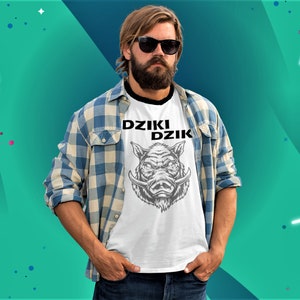 May include: A white t-shirt with a black and white graphic of a wild boar's head and the text "DZIKI DZIK". The person wearing the shirt is wearing a blue and white plaid shirt and jeans.
