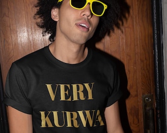 Peut inclure: T-shirt noir avec le texte doré "VERY KURWA NICE". La personne sur l'image porte des lunettes de soleil jaunes et a une afro. L'arrière-plan est une porte en bois.